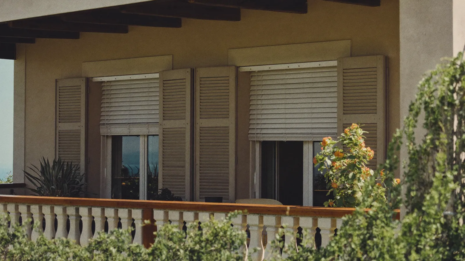 Terrasse ombragée d'un appartement cannois avec stores et volets fermés face à la chaleur